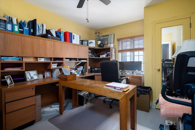 carpeted home office featuring ceiling fan