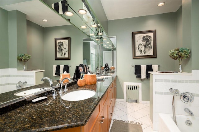 bathroom featuring tile patterned floors, radiator, vanity, and tiled tub