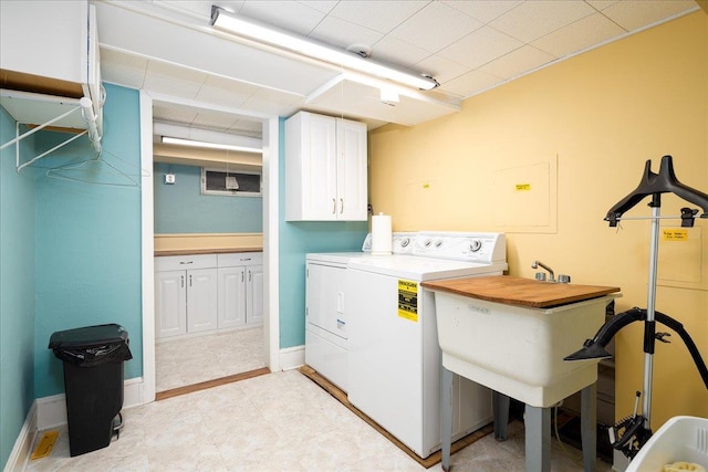 laundry area featuring washer and clothes dryer and cabinets