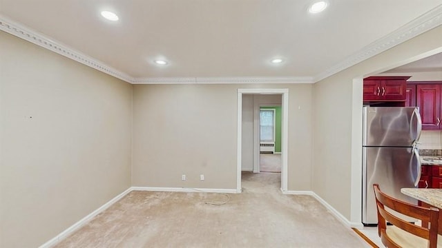 kitchen with light carpet, stainless steel refrigerator, and ornamental molding