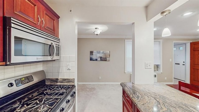 kitchen featuring decorative light fixtures, decorative backsplash, ornamental molding, stone countertops, and stainless steel appliances