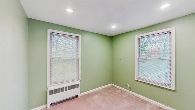 carpeted spare room featuring radiator