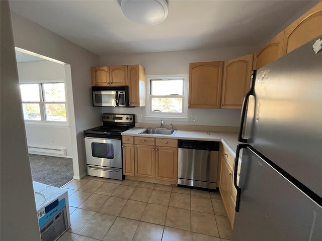 kitchen featuring light brown cabinetry, stainless steel appliances, a baseboard heating unit, sink, and light tile patterned floors