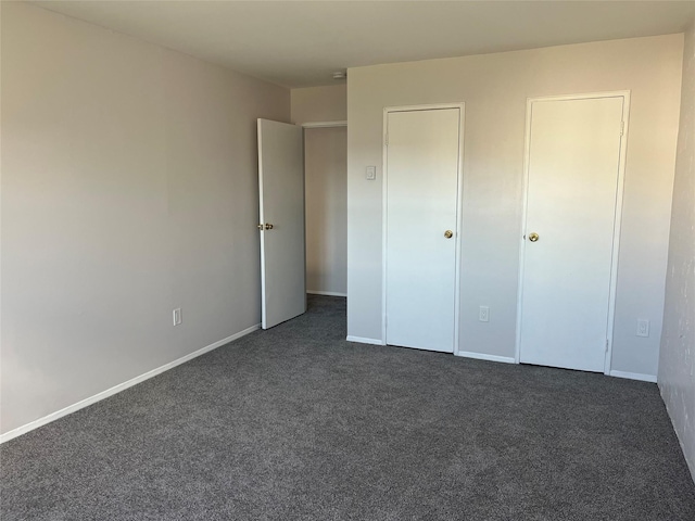 unfurnished bedroom with dark carpet