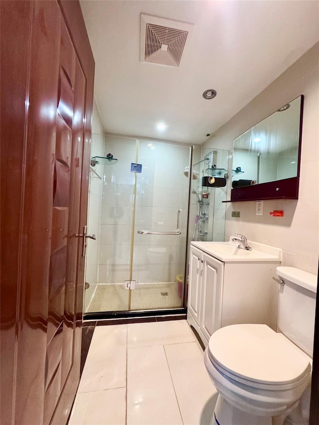 bathroom featuring tile patterned flooring, vanity, toilet, and an enclosed shower