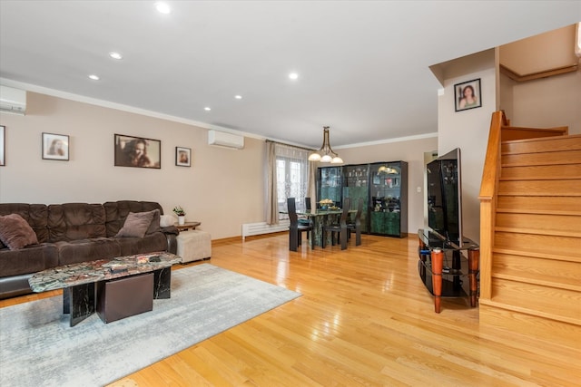 living room featuring light wood-type flooring, an inviting chandelier, a wall unit AC, and ornamental molding