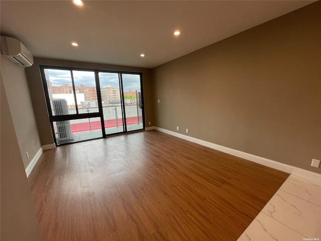 unfurnished room featuring a wall unit AC and dark wood-type flooring