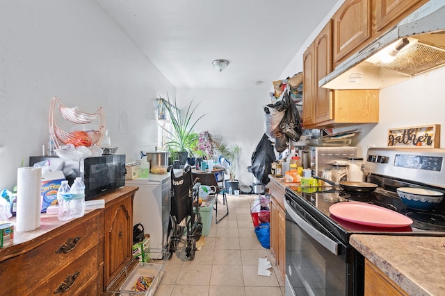 kitchen with stainless steel electric stove and light tile patterned floors