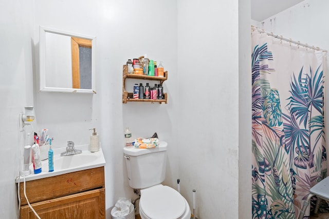 bathroom featuring a shower with shower curtain, vanity, and toilet