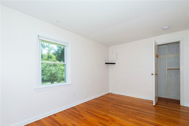 unfurnished room with wood-type flooring