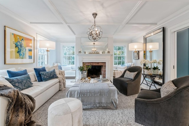 living room featuring a fireplace, carpet, coffered ceiling, and a notable chandelier