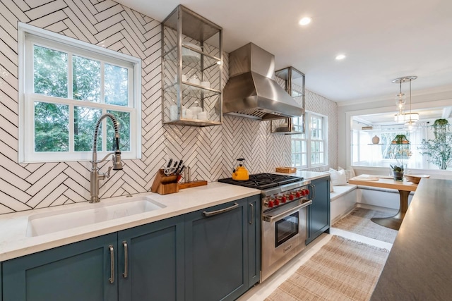 kitchen with decorative light fixtures, ventilation hood, plenty of natural light, and luxury stove