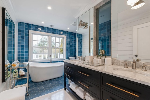 bathroom featuring a washtub, vanity, tile walls, and tile patterned flooring