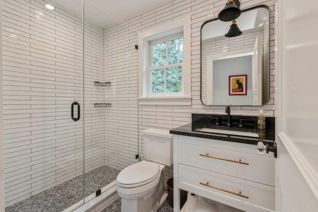 bathroom featuring vanity, an enclosed shower, tile walls, and toilet