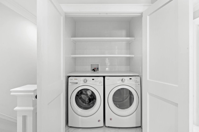 clothes washing area with crown molding and washer and clothes dryer