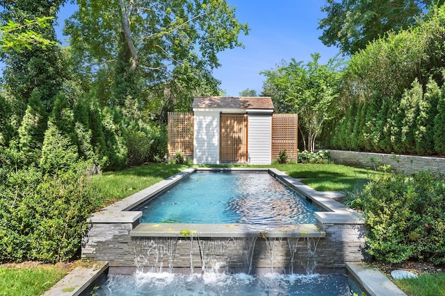 view of pool with a storage shed and a lawn