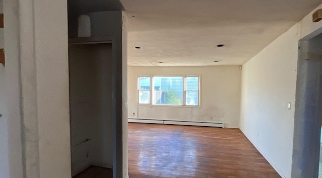 hallway featuring wood-type flooring and a baseboard radiator