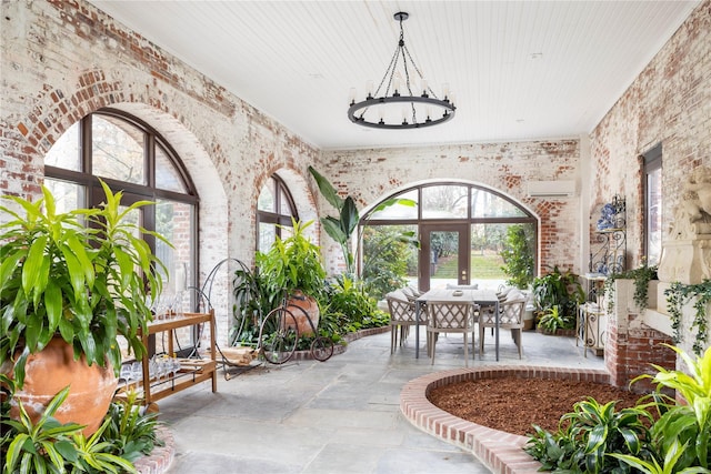 interior space featuring a wall mounted air conditioner, wooden ceiling, an inviting chandelier, french doors, and brick wall