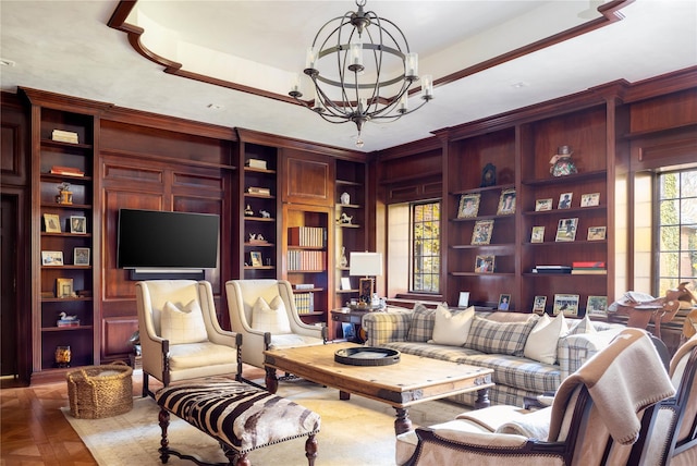 living room with a notable chandelier, built in features, and parquet flooring