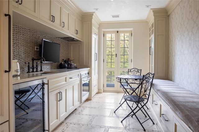 kitchen featuring stainless steel oven, backsplash, french doors, wine cooler, and ornamental molding