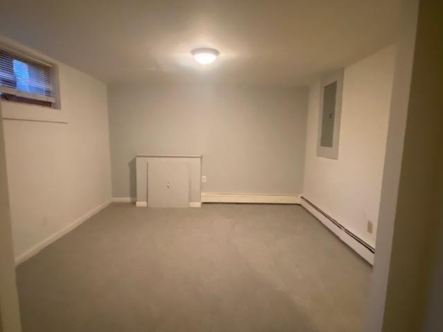 basement featuring carpet flooring, electric panel, and a baseboard heating unit