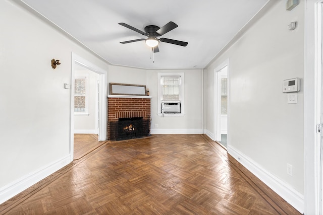 unfurnished living room featuring cooling unit, dark parquet floors, ceiling fan, and a brick fireplace