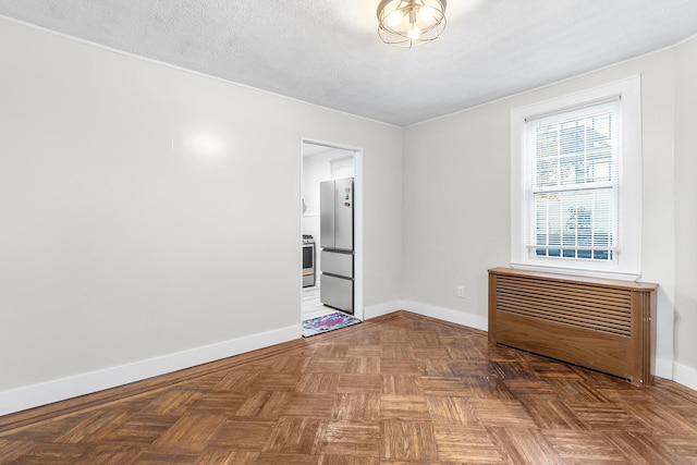 empty room featuring parquet flooring and a textured ceiling