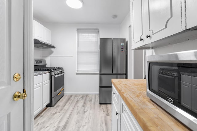 kitchen featuring white cabinets, light wood-type flooring, stainless steel appliances, and butcher block counters