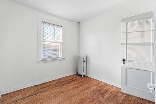 spare room featuring hardwood / wood-style flooring and radiator