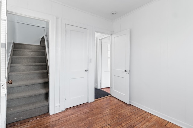 staircase featuring hardwood / wood-style flooring and crown molding