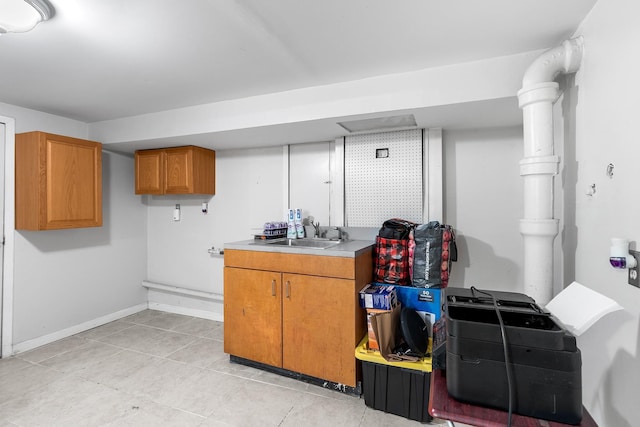 basement with sink and light tile patterned floors