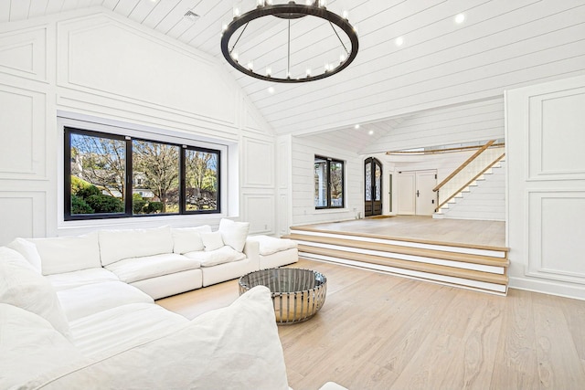 living room with high vaulted ceiling and light hardwood / wood-style floors