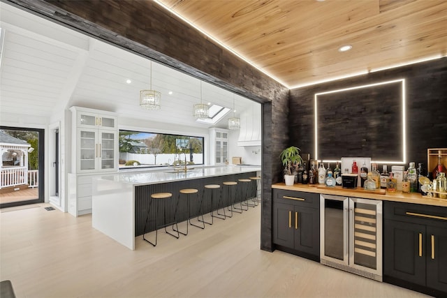 bar featuring wooden ceiling, wine cooler, hanging light fixtures, and a notable chandelier