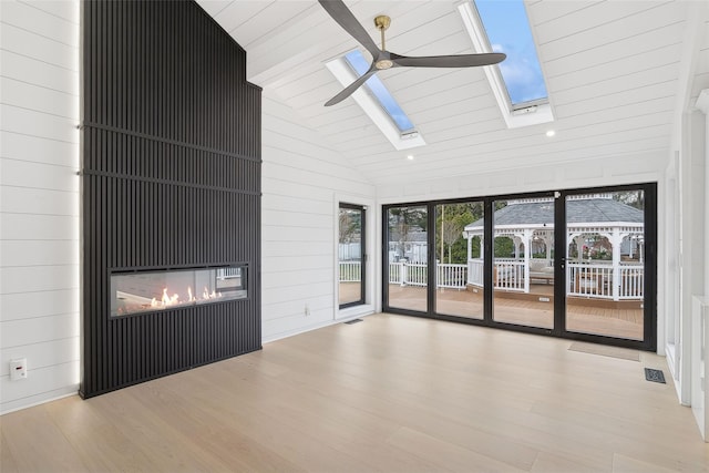 unfurnished living room with ceiling fan, light hardwood / wood-style floors, and high vaulted ceiling