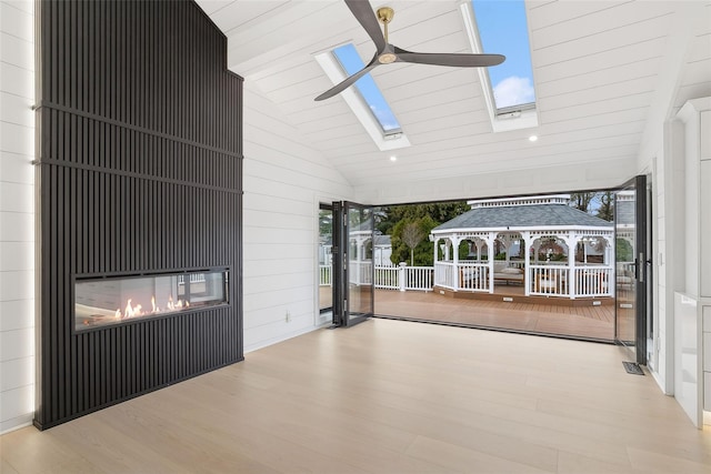 view of patio featuring ceiling fan, a gazebo, a fireplace, and covered porch