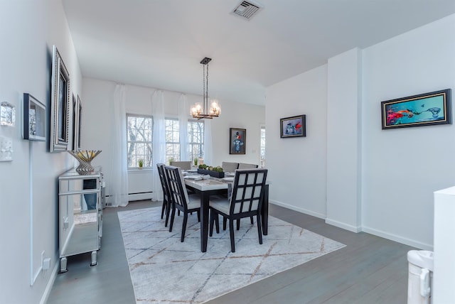 dining space with hardwood / wood-style flooring and a notable chandelier