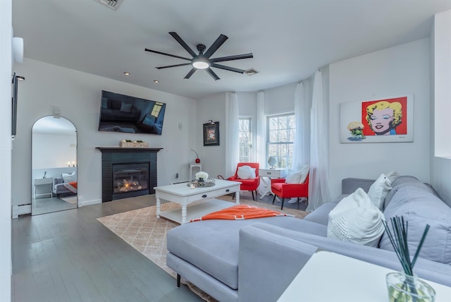 living room featuring ceiling fan, dark hardwood / wood-style flooring, and baseboard heating