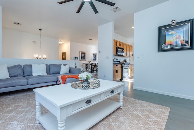 living room featuring wood-type flooring and ceiling fan with notable chandelier