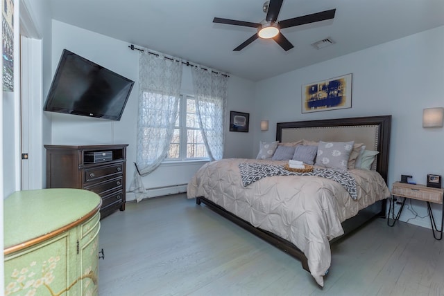 bedroom with ceiling fan, wood-type flooring, and a baseboard radiator