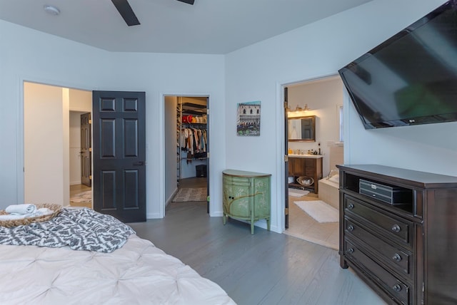 bedroom featuring ensuite bath, ceiling fan, light wood-type flooring, a spacious closet, and a closet