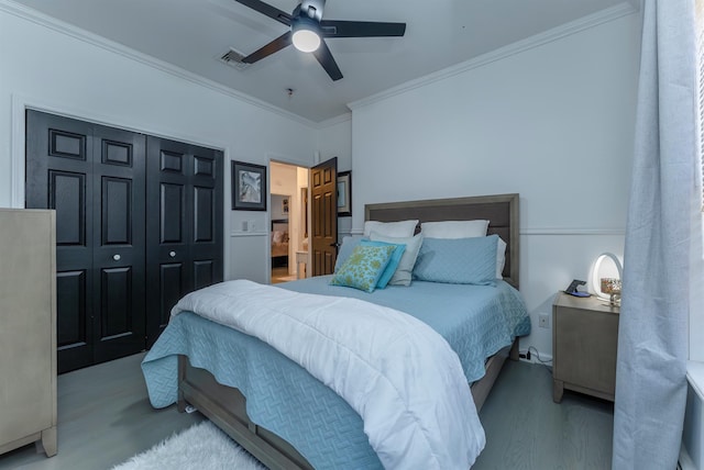 bedroom with ceiling fan, wood-type flooring, crown molding, and a closet