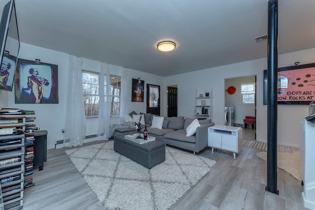 living room featuring light wood-type flooring and independent washer and dryer