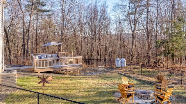 view of yard featuring an outdoor fire pit, central AC, and a deck