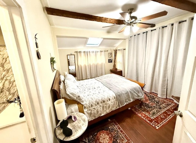 bedroom featuring wood-type flooring, ceiling fan, and vaulted ceiling with skylight