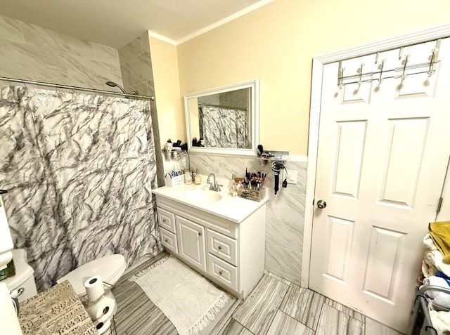 bathroom with walk in shower, crown molding, toilet, vanity, and tile walls