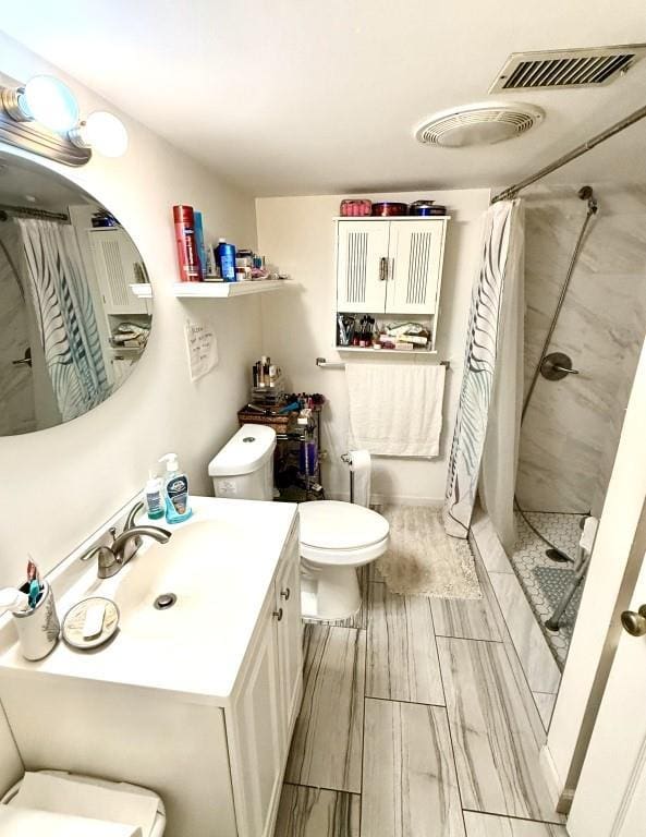 bathroom with a shower with shower curtain, vanity, and toilet