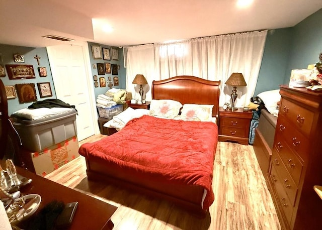 bedroom featuring visible vents and wood finished floors
