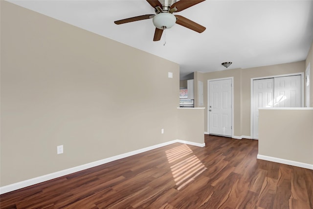 empty room with ceiling fan and dark wood-type flooring