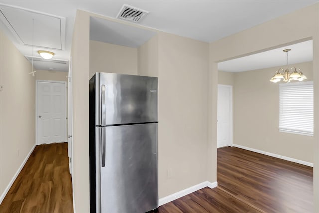 kitchen featuring dark hardwood / wood-style floors, stainless steel refrigerator, and a notable chandelier