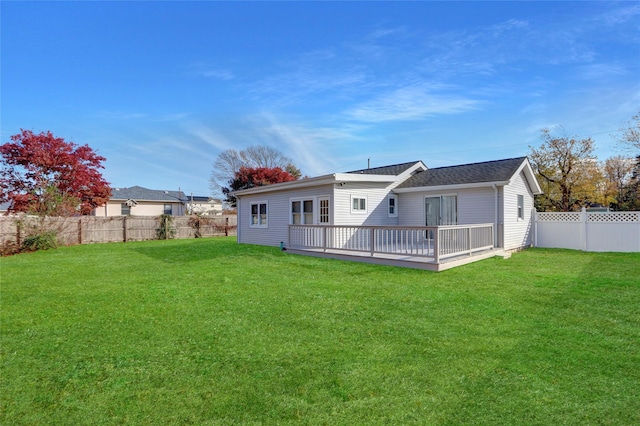 rear view of property featuring a wooden deck and a yard